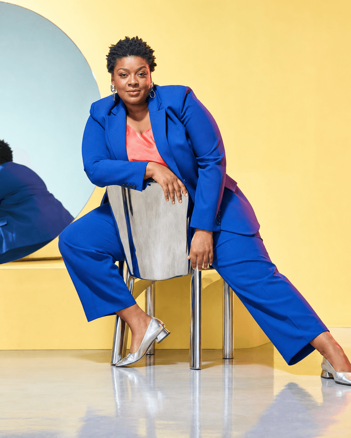 Modèle AI en costume bleu sur une chaise chromée