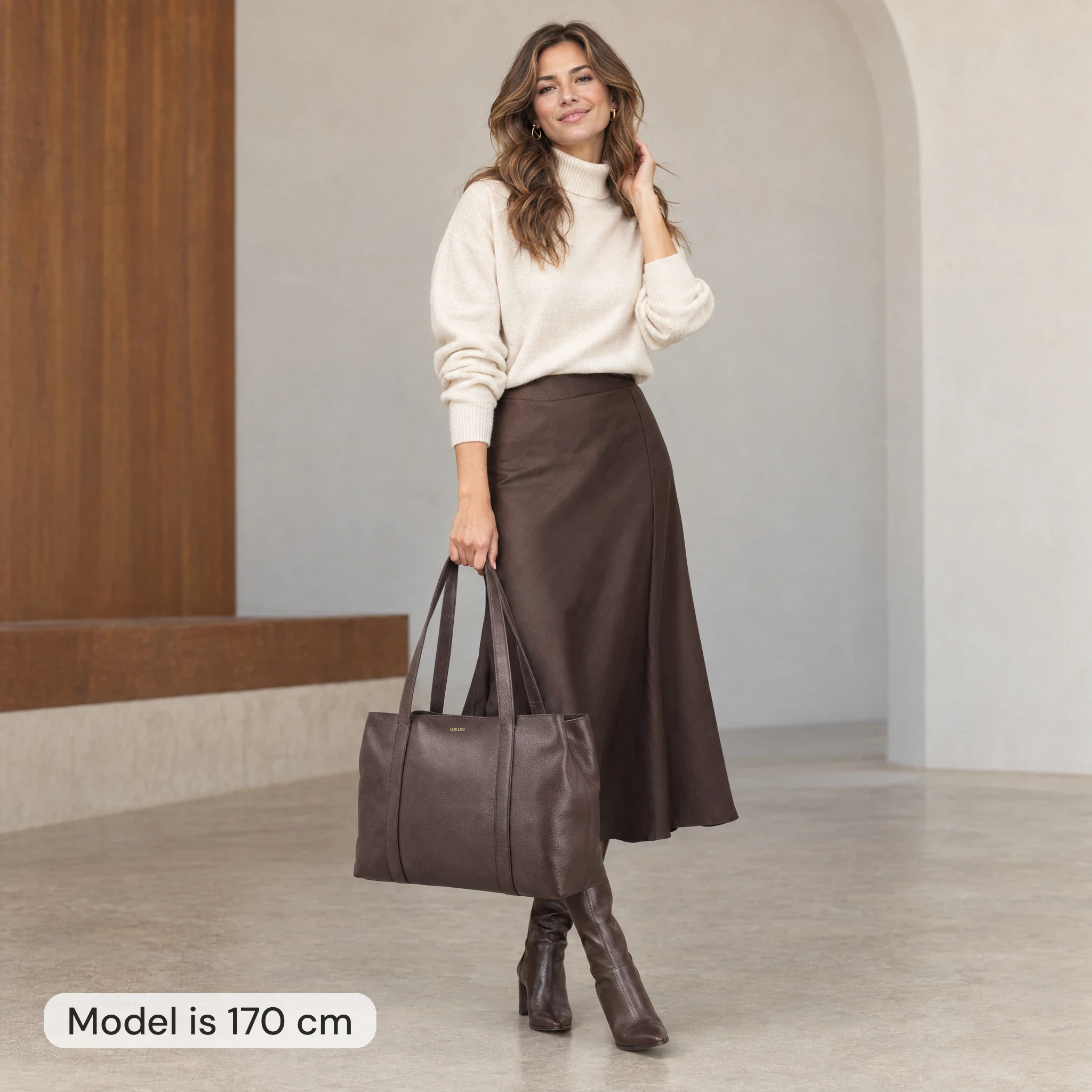 AI model image: a 170 cm woman holding a brown Loulou shopper, 50 cm wide