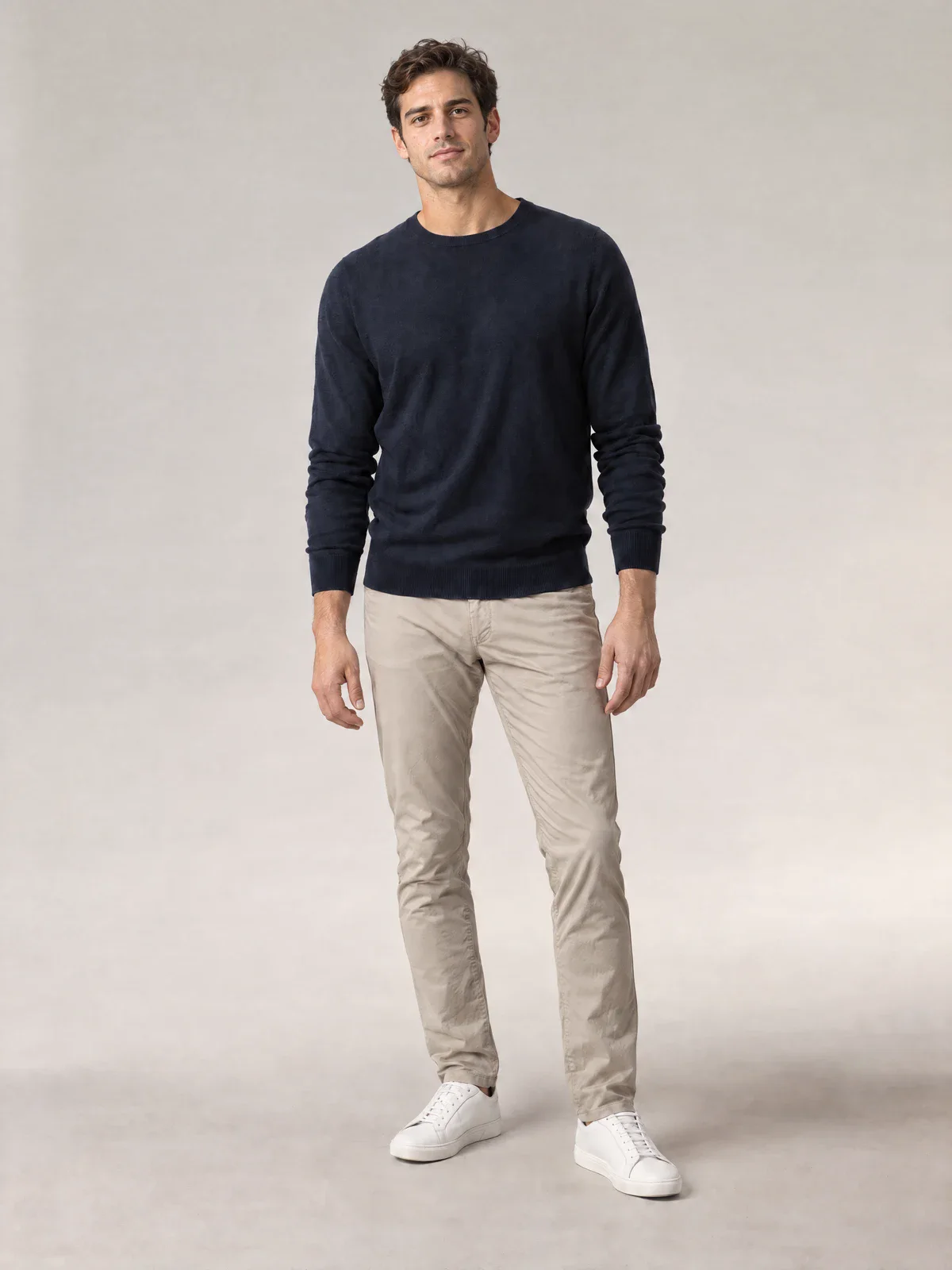 The same photo with the fixed AI House Model: only the face and hair are replaced; the sweater, chinos, pose and lighting stay the same