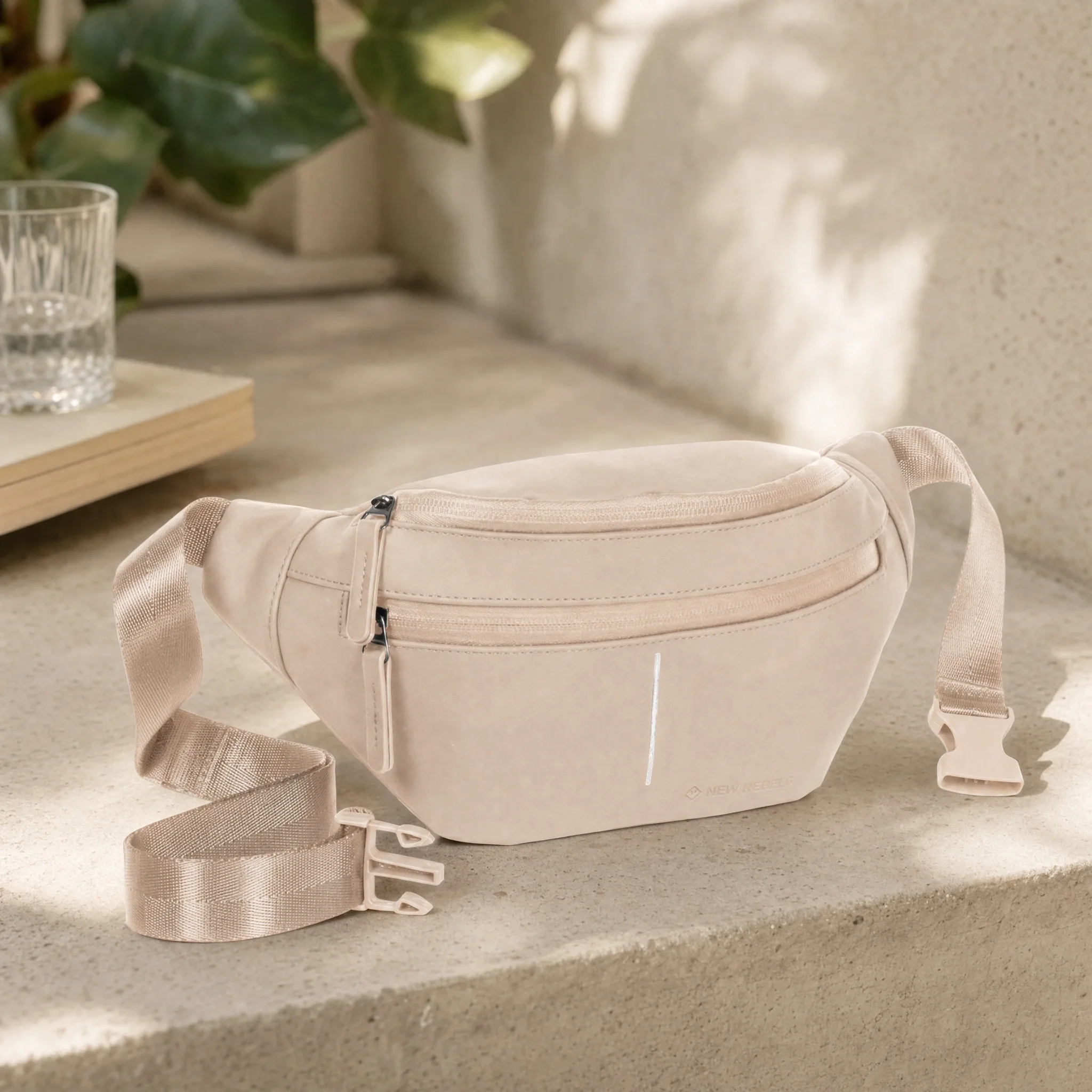Image d’ambiance : sac banane vieux rose avec double fermeture éclair sur une marche en pierre