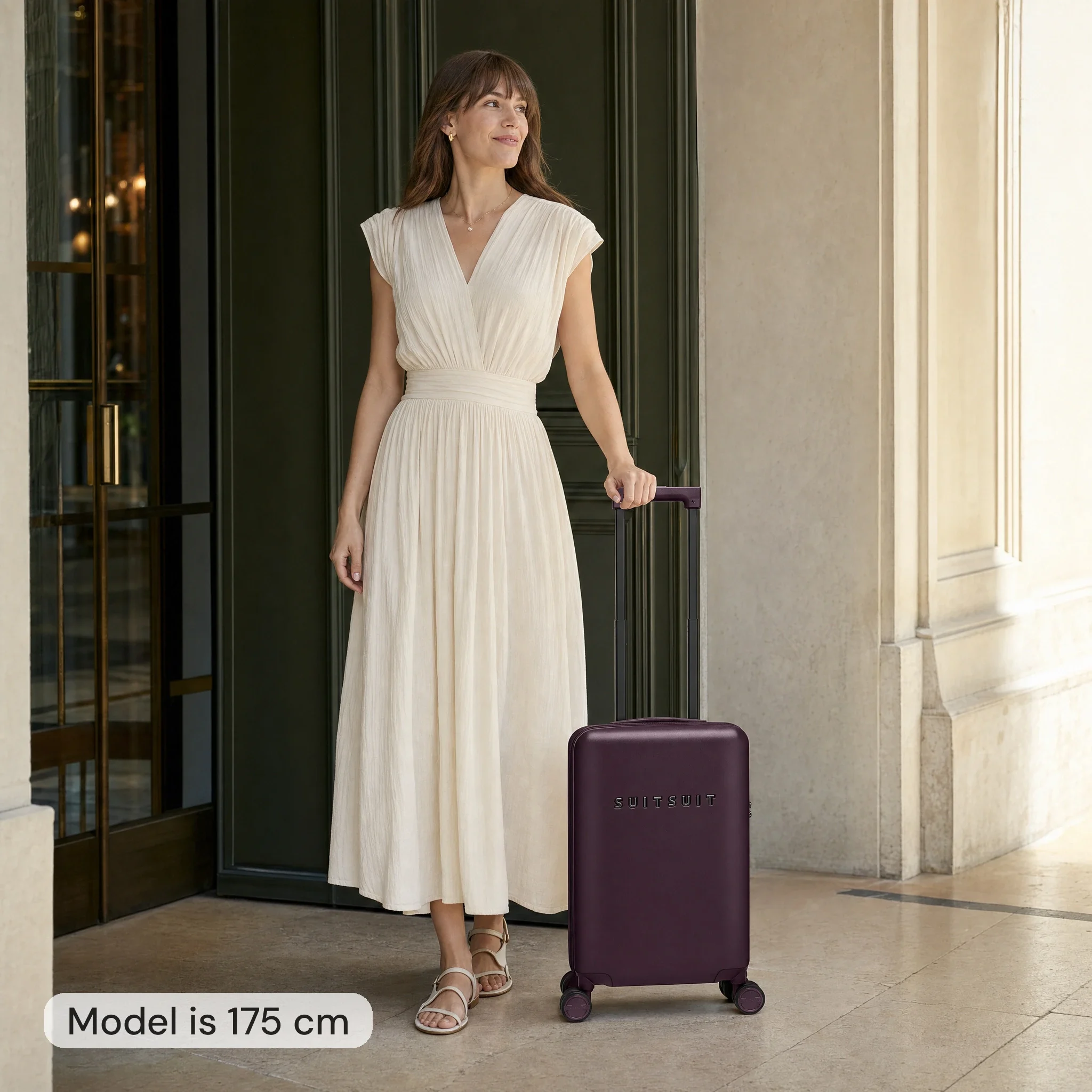 AI-modellbild: kvinna på 175 cm bredvid en vinröd Suitsuit-handbagageväska som är 54 cm hög