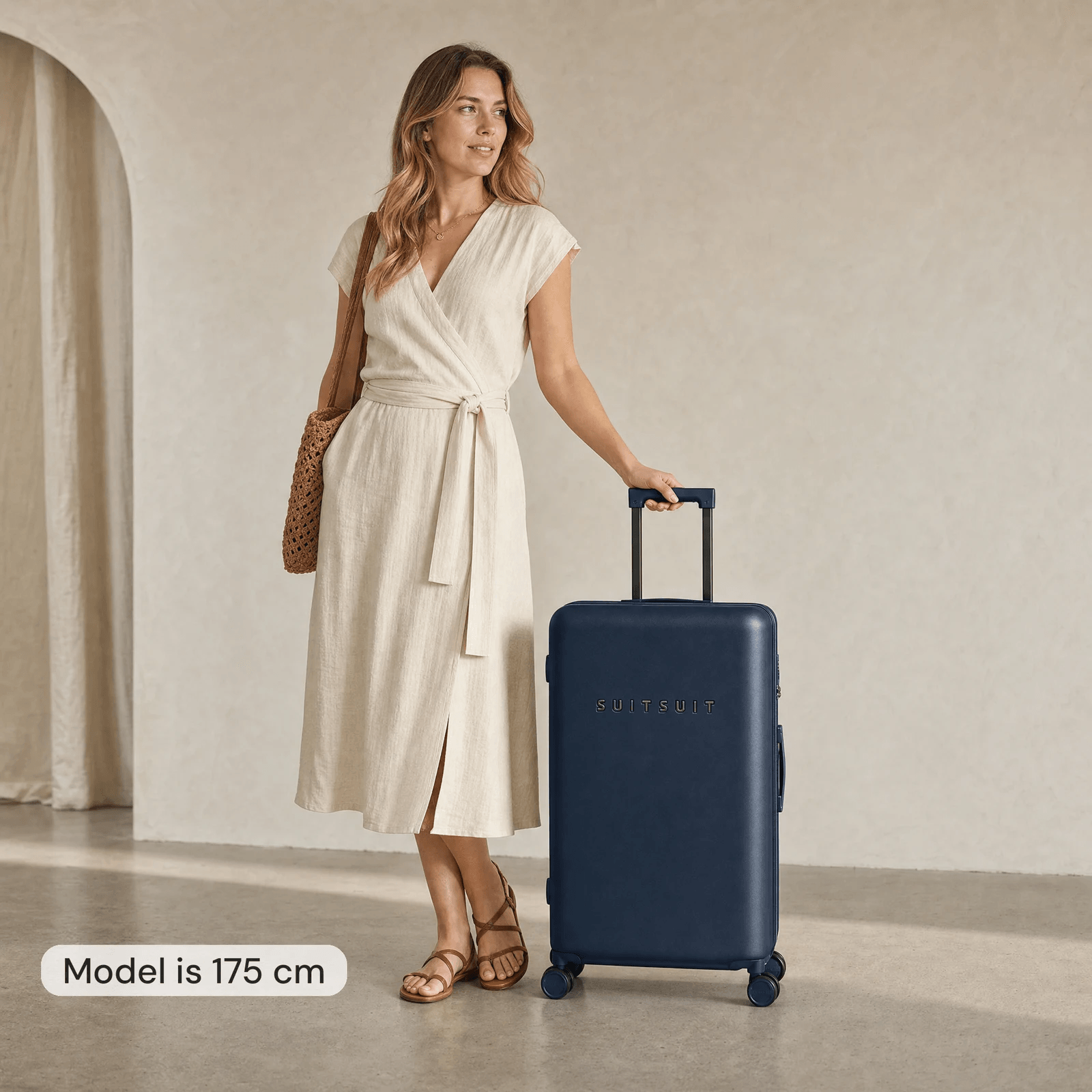 Woman of 175 cm next to a dark blue 76 cm Suitsuit suitcase