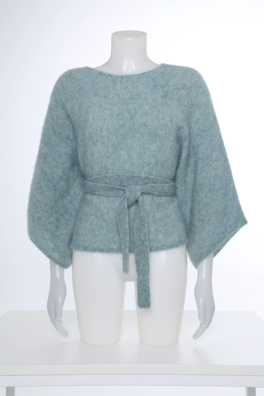 Mint green knitted top with a tie belt on a mannequin