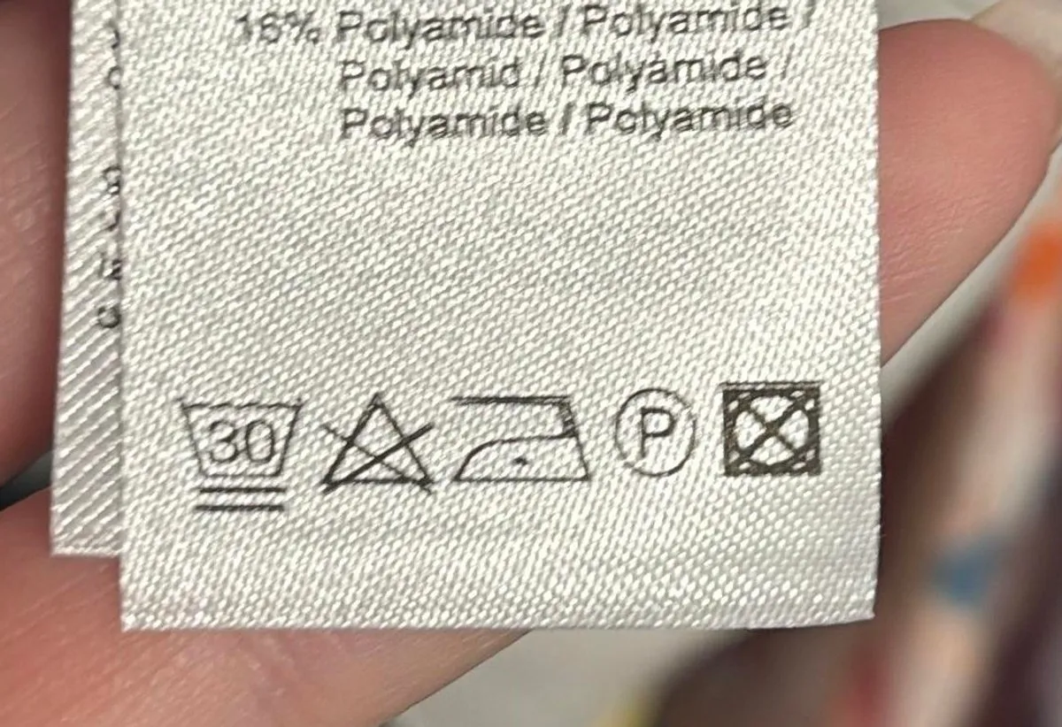 Foto af en vaskeanvisning med vaskesymboler